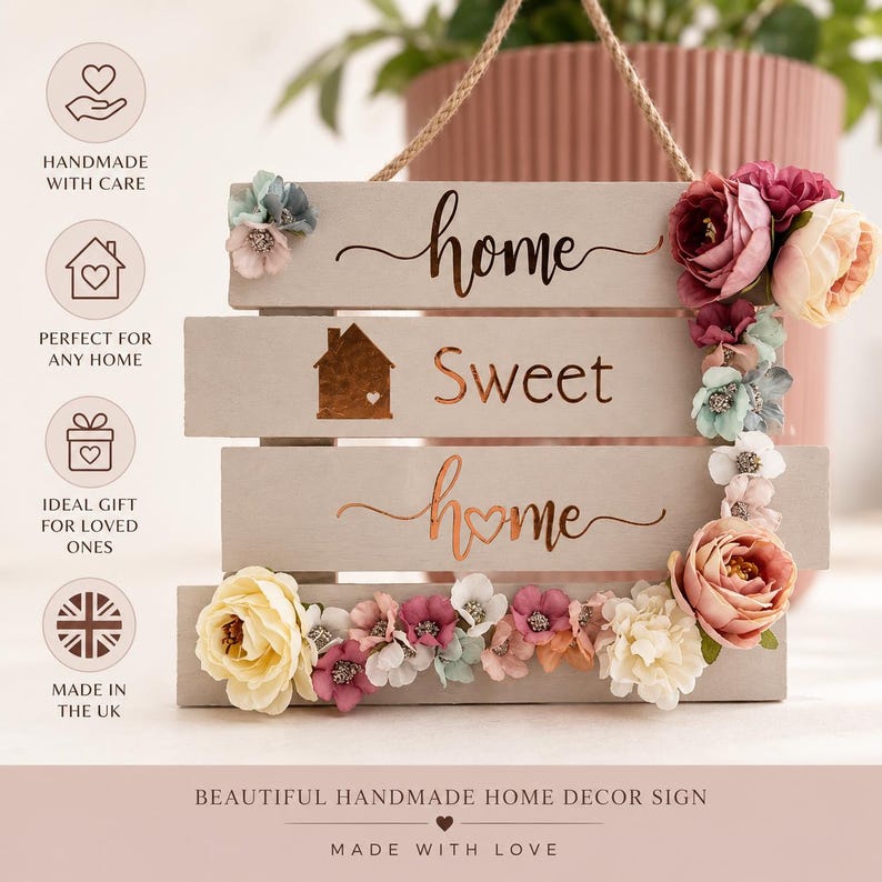May include: A wooden home decor sign with the words "home sweet home" in a decorative font. The sign is adorned with colorful artificial flowers and has a rope for hanging. The sign is handmade and made in the UK.