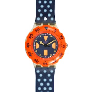 Puede incluir: Un reloj Swatch de color naranja brillante y blanco con una esfera negra y una correa de lunares azul y blanco.