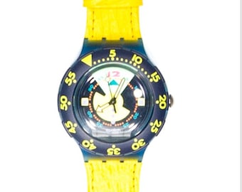 May include: A yellow and blue Swatch watch with a black face and a yellow strap. The watch has a rotating bezel with numbers from 5 to 60. The face of the watch has a small compass and a date window.