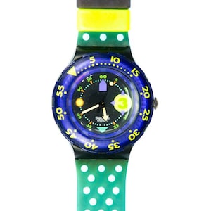 以下が含まれることがあります： 黒色の文字盤と緑と白のドット模様のバンドが付いた青と黄色のスウォッチの腕時計です。
