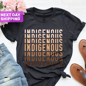 May include: Black t-shirt with the word "INDIGENOUS" repeated in a gradient of brown shades.