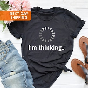 May include: Black t-shirt with a white loading circle graphic and the text "I'm thinking..."