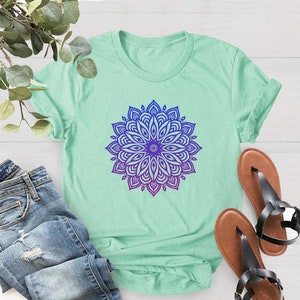 May include: A light green t-shirt with a purple and blue mandala design.