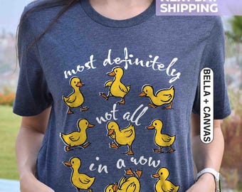 May include: Heather navy blue t-shirt with the phrase "most definitely not all in a row" and illustrations of yellow ducklings. The shirt is made of Bella + Canvas material.