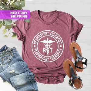 May include: A maroon t-shirt with a white circle graphic that says "Respiratory Therapist" with a caduceus symbol and the letters "RT" inside the circle.