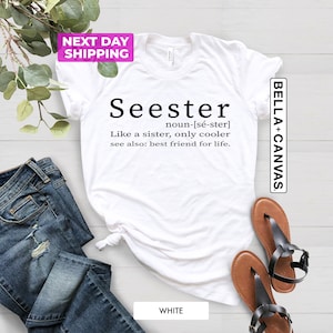 Pu&ograve; includere: Maglietta bianca con testo nero che dice "Seester noun-[s&eacute;-ster] Like a sister, only cooler see also: best friend for life."
