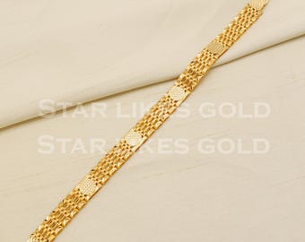 May include: A gold bracelet with a chain link design and round accents. The bracelet has a clasp closure.