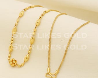 May include: Two gold chains, one with a textured oval link pattern and the other with a fine, woven link pattern. The chain with the oval links has a small, round, textured charm at one end.