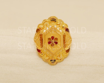 May include: A gold-colored ring with a floral design. The ring features a central hexagonal shape with a red flower and is surrounded by intricate filigree and red accents. The ring is set against a neutral background.