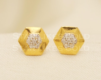 May include: A pair of gold hexagonal stud earrings with a cluster of small white stones in the centre of each earring.
