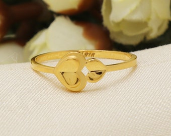 Anillo de oro de 22k con doble corazón y sello distintivo.