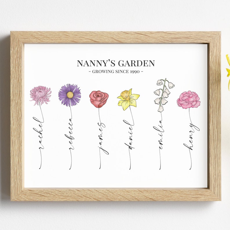 May include: A white framed print with the text "Nanny's Garden - Growing Since 1990" and six different flowers with names written underneath each flower: Rachel, Rebecca, James, Daniel, Emilia, and Henry.