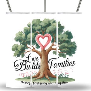 Op de afbeelding: Een witte beker met een ontwerp met een boom met een hartvormige top en de woorden "Love Builds Families" in zwart schrift. Het ontwerp bevat groene bladeren en de zin "through fostering and adoption."