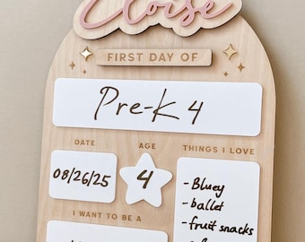 May include: Wooden first day of school sign with the name "Eloise" in pink script. The sign includes sections for "Pre-K 4", date, age, and "Things I Love", with a list including "Bluey" and "mermaid".