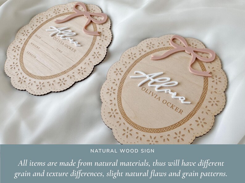 May include: Two oval wooden signs with scalloped edges and laser-cut floral patterns. Each sign features a raised dusty pink bow, white 3D script text reading "Allora", and the printed name "OLIVIA OCKER". One sign includes fields for date, weight, time, and length.