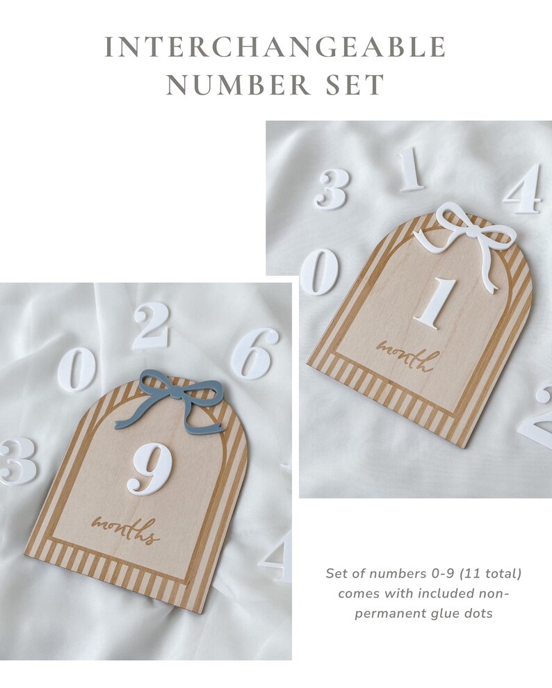 May include: An interchangeable number set featuring two arched wooden plaques with striped borders, one topped with a blue bow and the other with a white bow. The plaques display the text month or months, accompanied by a set of white numbers 0-9.