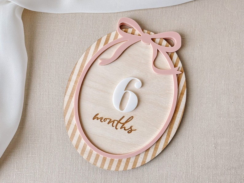 Our reversible milestone wood card, adorned with a delightful pink bow design, is perfect for commemorating your baby girl's monthly milestones.