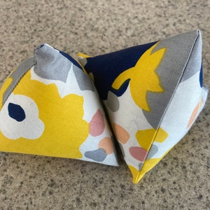 Pair of pyramid-shaped cat toys, floral pattern in pink, yellow, blue, and white, cotton fabric, stuffed with catnip and polyester filling