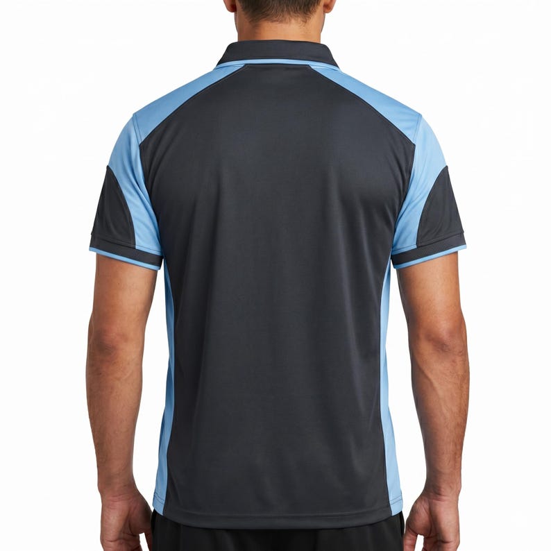 May include: A short-sleeve polo shirt featuring a dark charcoal gray center panel with light blue raglan-style sleeves and side panels. The shirt has a dark gray collar and matching dark gray sleeve cuffs with a thin light blue stripe detail.