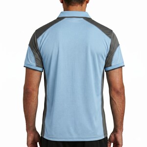 May include: A short-sleeved polo shirt featuring a light blue main body with dark gray panels on the shoulders and sides. The garment has a classic collar, a buttoned placket, and short sleeves with dark gray trim along the edges of the cuffs.