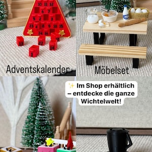 May include: A collection of miniature Christmas-themed items, including a red Advent calendar, a small table with food items, colorful music boxes, and a black appliance. The image includes text in German.
