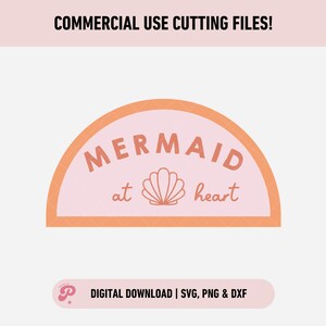 Op de afbeelding: Een roze en oranje halfronde ontwerp met de tekst "MERMAID at heart" en een schelpgrafiek.