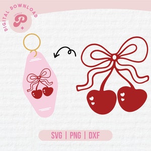 May include: A pink keychain featuring a red cherry design. The cherries have a bow on top and are tied together with a ribbon. The keychain is shaped like a hotel key.