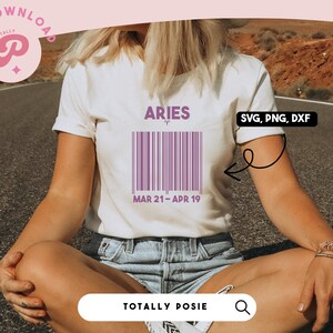 May include: A white t-shirt with a purple barcode design that says "Aries" and "MAR 21-APR 19". The design also includes the astrological symbol for Aries. The t-shirt is being worn by a person sitting on a road.