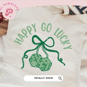 Puede incluir: Una bolsa de tela blanca con el texto "Happy Go Lucky" en verde y un lazo verde con dos dados verdes colgando de &eacute;l. El texto "Totally Posie" est&aacute; en la parte inferior de la bolsa.