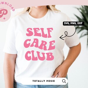 May include: A white t-shirt with the text "SELF CARE CLUB" in pink retro-style lettering. The text is centered on the shirt. The shirt is being worn by a person. The image also includes the text "SVG, PNG, DXF" in a white box with a black border.