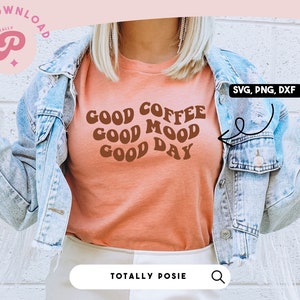 May include: A woman wearing a peach colored t-shirt with the text "GOOD COFFEE GOOD MOOD GOOD DAY" in brown retro font. She is wearing a light blue denim jacket and has her hands raised in a peace sign.
