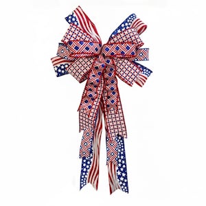 May include: A decorative bow featuring red, white, and blue ribbons with patriotic patterns. The bow includes stripes, stars, and diamond designs, perfect for Independence Day or other patriotic celebrations.