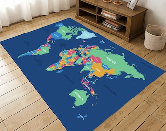 May include: A rectangular blue area rug featuring a colorful world map design. The continents are depicted in various colors, with country names labeled. The rug is placed on a wooden floor, with a wooden cabinet and decor in the background.