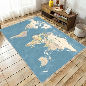 Puede incluir: Una alfombra azul y beige con un mapa del mundo, fronteras y nombres de países. La alfombra está sobre un suelo de madera clara.