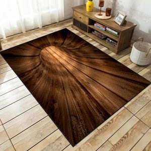 May include: A brown and black area rug with a wood grain pattern. The rug has a circular design in the center that looks like a tunnel.