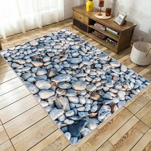 May include: A gray and white area rug with a realistic pebble stone design. The rug is made of soft, durable material and is perfect for adding a touch of nature to any room.