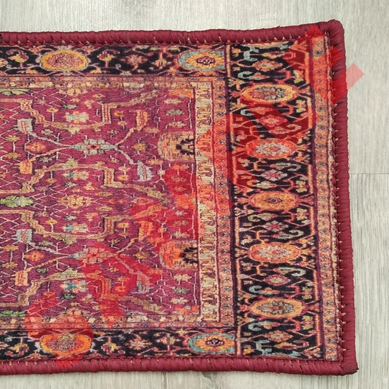 Pu&ograve; includere: Un tappeto rosso, arancione e nero con un bordo bordeaux. Il tappeto ha un design persiano tradizionale.