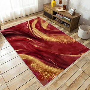 Può includere: Tappeto da area astratto rosso e oro con un motivo a spirale. Il tappeto ha un design moderno con un effetto acquerello.
