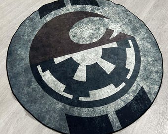 May include: A round rug with a distressed, faded design featuring the Rebel Alliance and Imperial symbols in black, white, and gray.