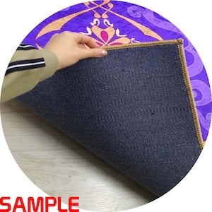 Puede incluir: Una alfombra redonda con un dise&ntilde;o morado y dorado, con un reverso azul oscuro. El dise&ntilde;o de la alfombra presenta patrones florales y geom&eacute;tricos. La palabra "SAMPLE" es visible en rojo en la parte inferior de la imagen.