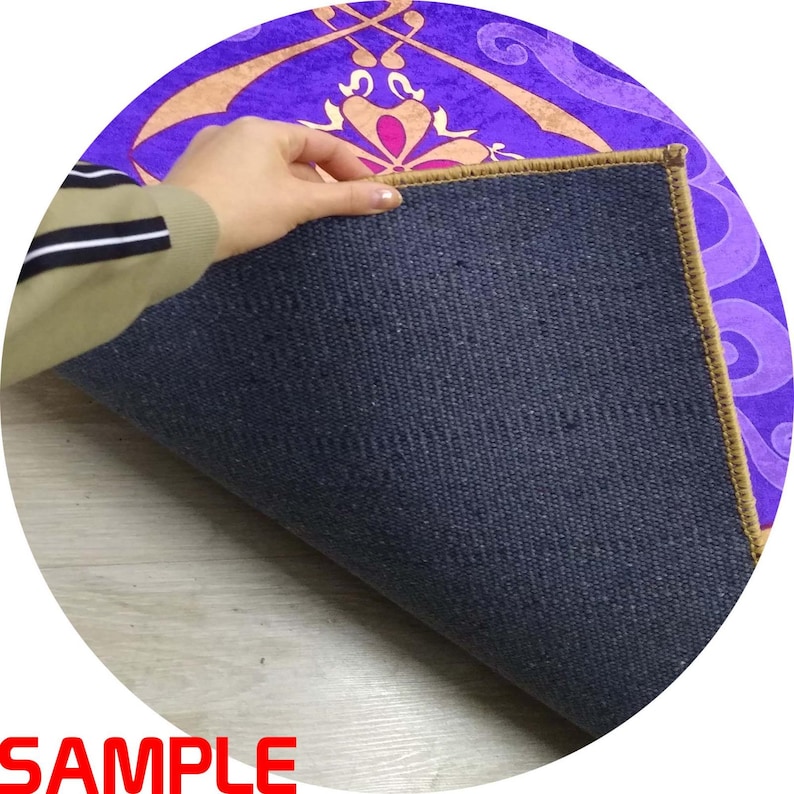Puede incluir: Una alfombra redonda con un dise&ntilde;o morado y dorado, con un reverso azul oscuro. El dise&ntilde;o de la alfombra presenta patrones florales y geom&eacute;tricos. La palabra "SAMPLE" es visible en rojo en la parte inferior de la imagen.