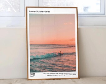 May include: A framed print with a sunset over the ocean and a surfer riding a wave. The print has the text "Summer Dictionary Series" and "SURF /sarf/ riding waves on a board an art form that connects you with nature the most freeing activity, and the greatest sport of all time"