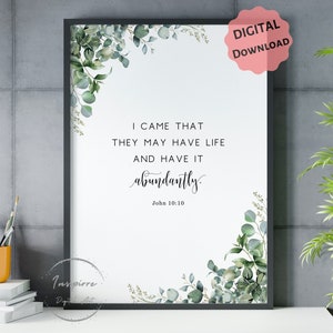 May include: A printable wall art design with a white background and a black frame. The design features a green eucalyptus leaf border and a quote from the Bible, "I came that they may have life and have it abundantly." John 10:10.