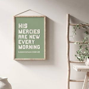 May include: A framed print with a green background and white text that reads "His mercies are new every morning" with the scripture reference "Lamentations 3:22-23" below the text.