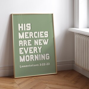 May include: A framed print with a green background and white text that reads "His mercies are new every morning" with the scripture reference "Lamentations 3:22-23" below the text.
