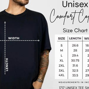 K&ouml;nnte beinhalten: Ein schwarzes T-Shirt mit einer Gr&ouml;&szlig;entabelle, die L&auml;ngen- und Breitenma&szlig;e in Zoll f&uuml;r die Gr&ouml;&szlig;en S bis 4XL anzeigt. Der Text lautet Unisex Comfort Colors Size Chart, mit Spalten f&uuml;r Gr&ouml;&szlig;e, L&auml;nge und Breite sowie 1717 Unisex Tee Shirt unten.