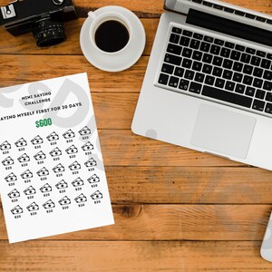 May include: A printable mini saving challenge worksheet with the text "Mini Saving Challenge" and "Paying Myself First for 30 Days $600". The worksheet has 30 rows of $10 bills.
