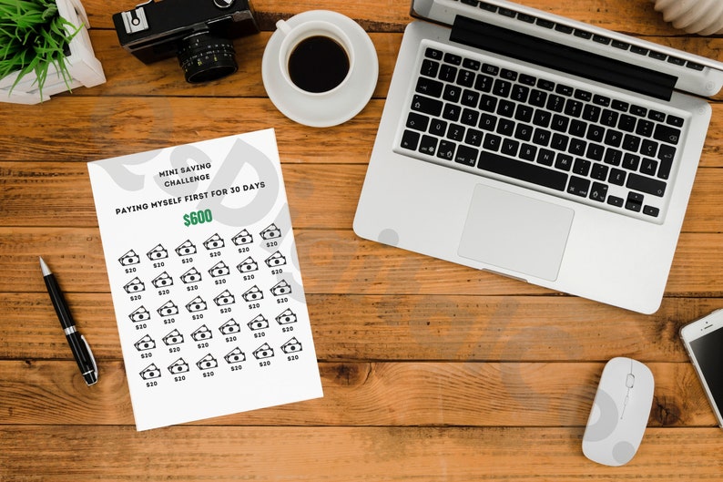 May include: A printable mini saving challenge worksheet with the text "Mini Saving Challenge" and "Paying Myself First for 30 Days $600". The worksheet has 30 rows of $10 bills.