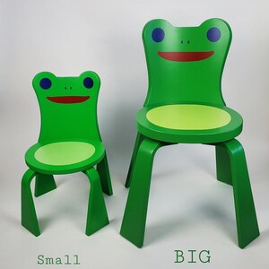 Puede incluir: Dos sillas infantiles verdes con forma de rana. La silla más pequeña está etiquetada como "Small" y la más grande como "BIG".