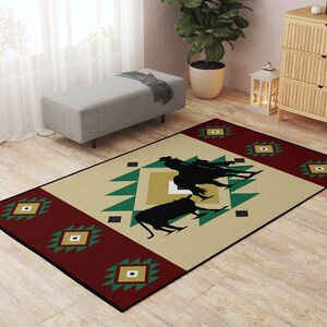 May include: A beige, red, and green area rug with a southwestern design. The rug features a geometric pattern with a silhouette of cowboys riding horses in the center.